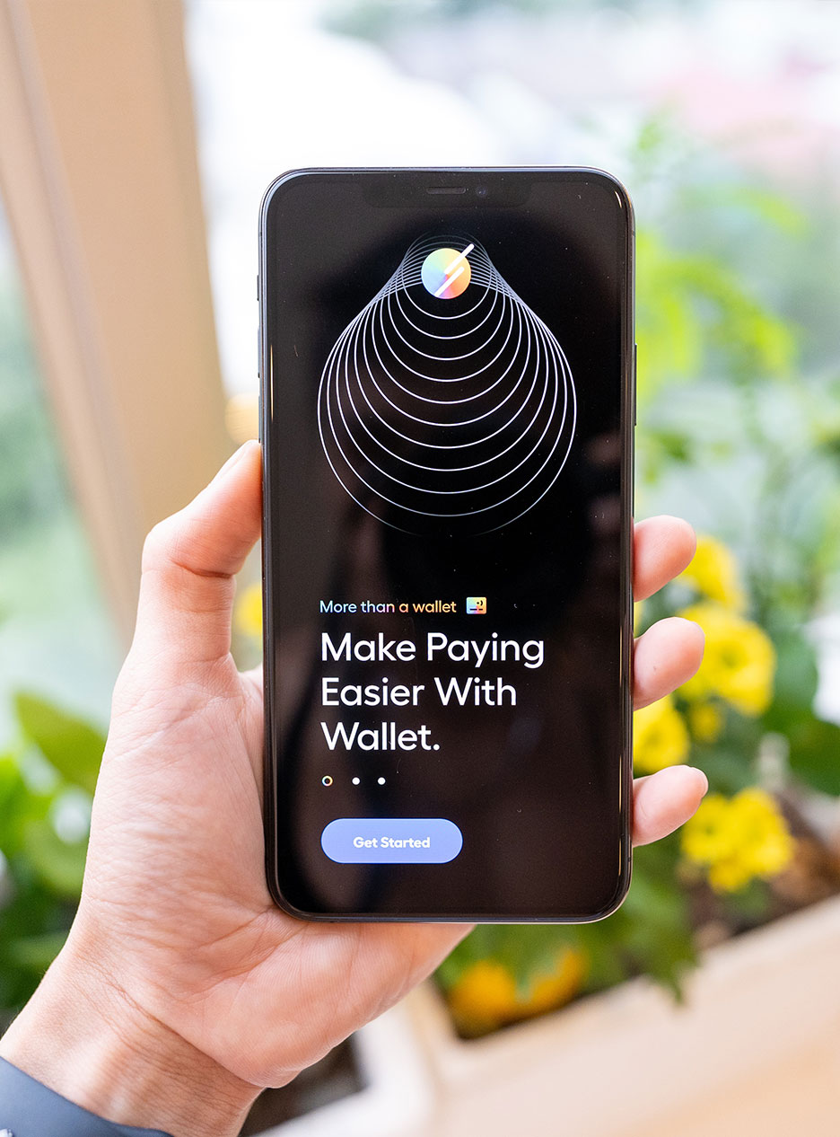 info-12 "Person holding smartphone displaying digital wallet app interface with message 'Make Paying Easier With Wallet'."